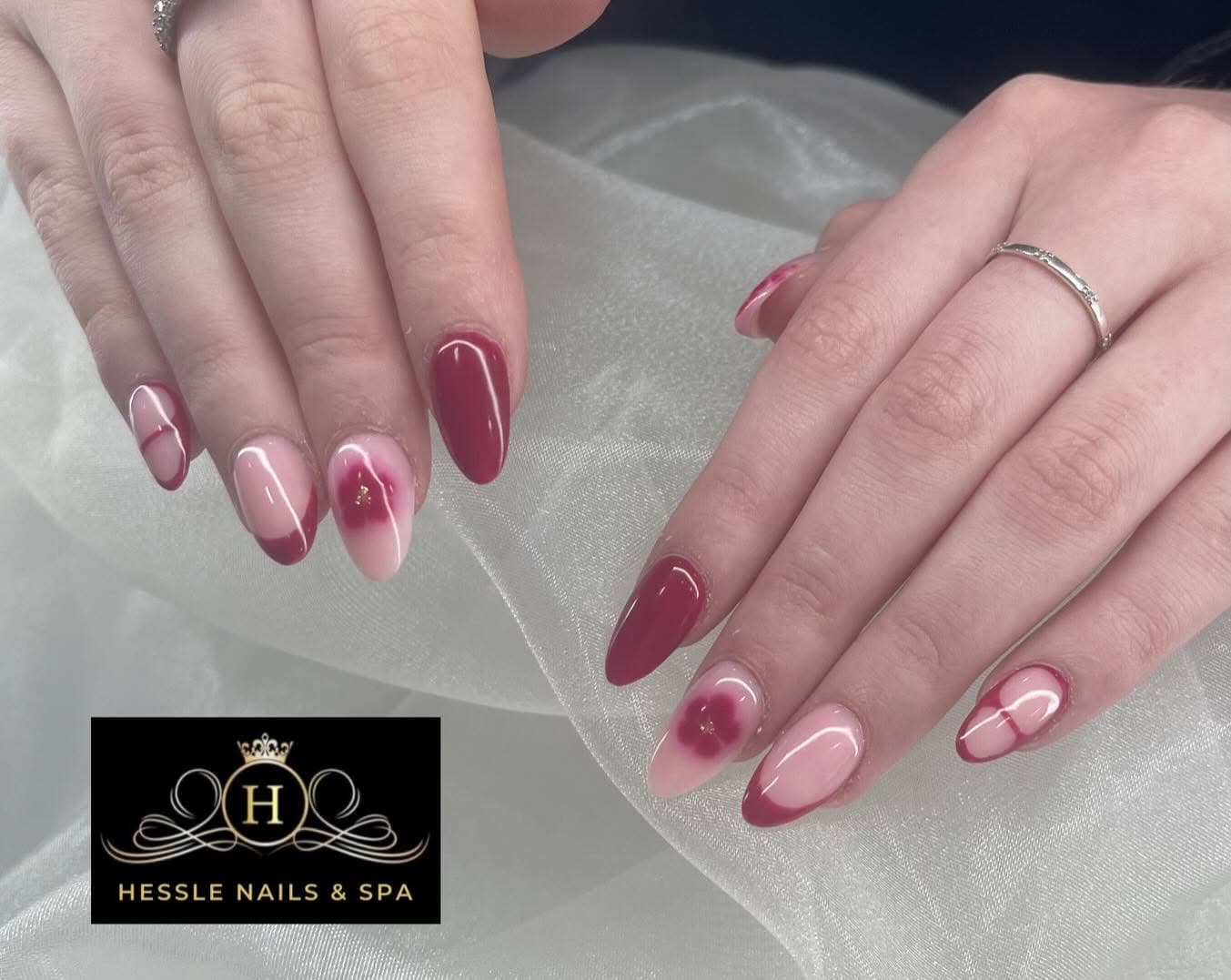 Burgundy gel nails with a soft pink flower accent nail
