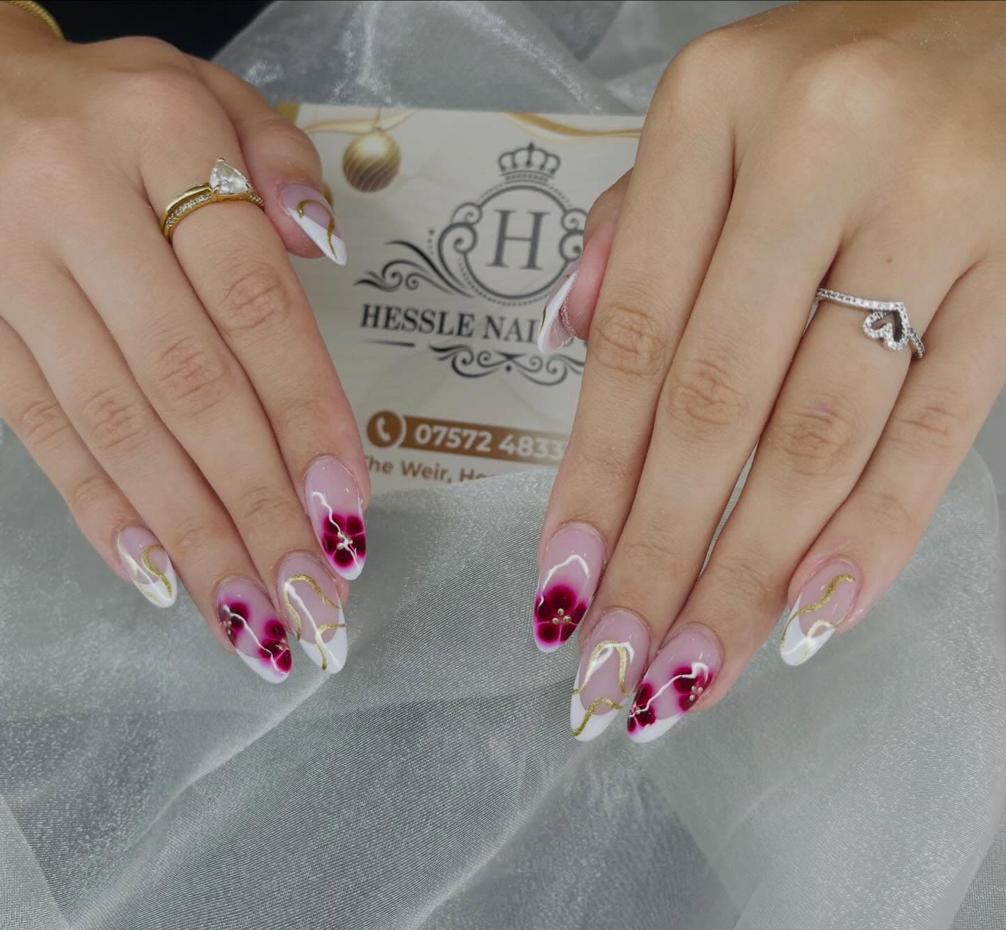 White and burgundy floral nail art with gold detailing